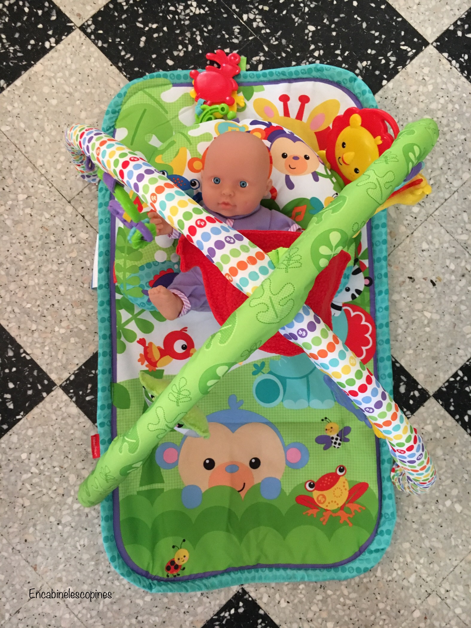 Un tapis d'éveil de Fisher Price multicouleurs avec des animaux de la jungle.